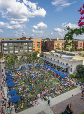 This image shows the vibrant Pearl District, a trendy neighborhood filled with charming restaurants, boutique shops, and a bustling farmers’ market. People are seen dining at outdoor cafes, shopping for artisanal goods, and enjoying live music in the open-air courtyard. The historic brewery buildings add character to the scene, making it a stylish and lively destination for food lovers and culture enthusiasts.