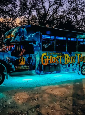 This image shows a thrilling ghost tour in downtown San Antonio at night. A guide, dressed in historical attire, holds a lantern while leading a group through dark alleys and haunted buildings. The eerie glow of streetlights casts shadows on historic structures like the Menger Hotel, where ghostly legends come to life. The mysterious ambiance and chilling stories make for an unforgettable spooky adventure.